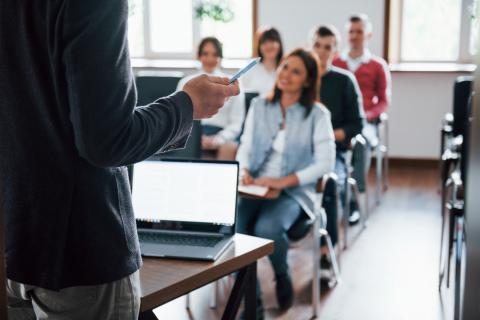 Obraz pobrany z https://www.freepik.com/, osoby siedzą w sali i słuchają wykładowcy